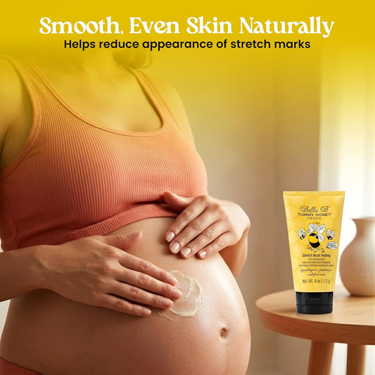 Pregnant woman applying cream to her belly with a bottle 